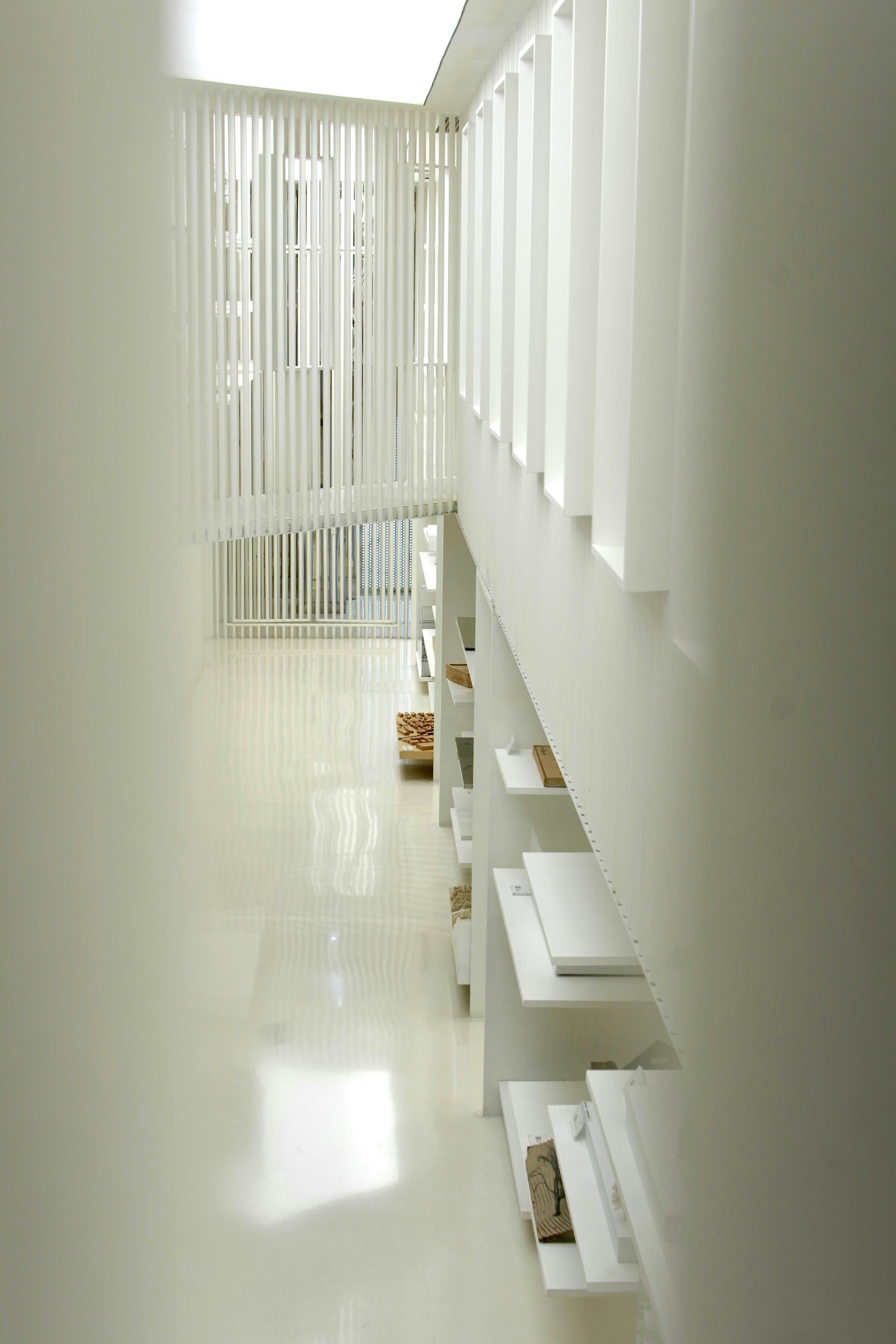 Białe minimalistyczne wnętrze z półkami i naturalnym światłem